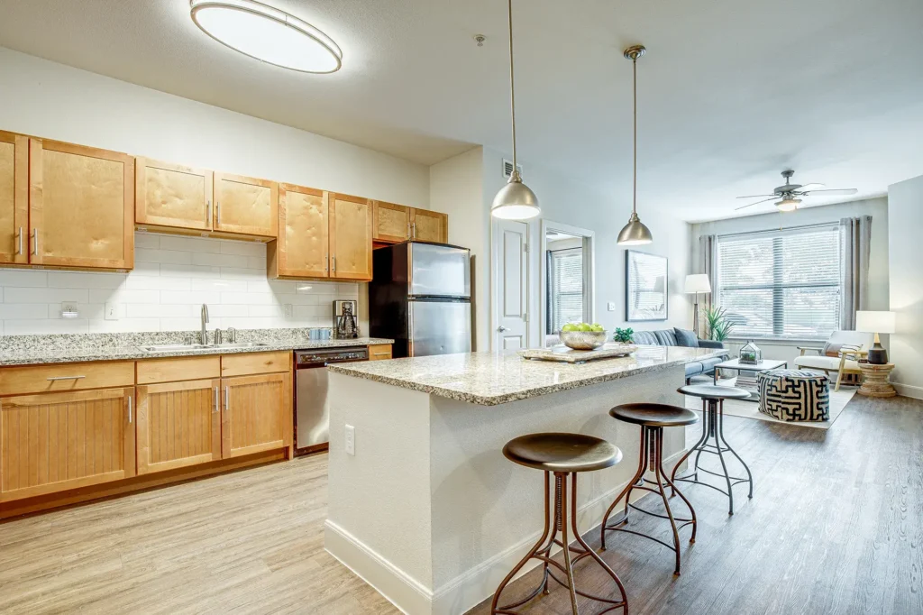 Kitchen with granite counters, stainless appliances, and tile backsplash, with bar seating at the island