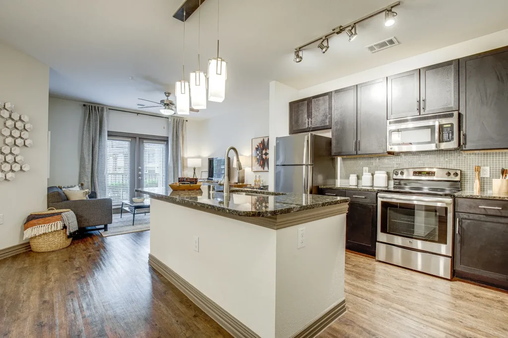 Kitchen with granite counters, stainless steel appliances, and tile backsplash