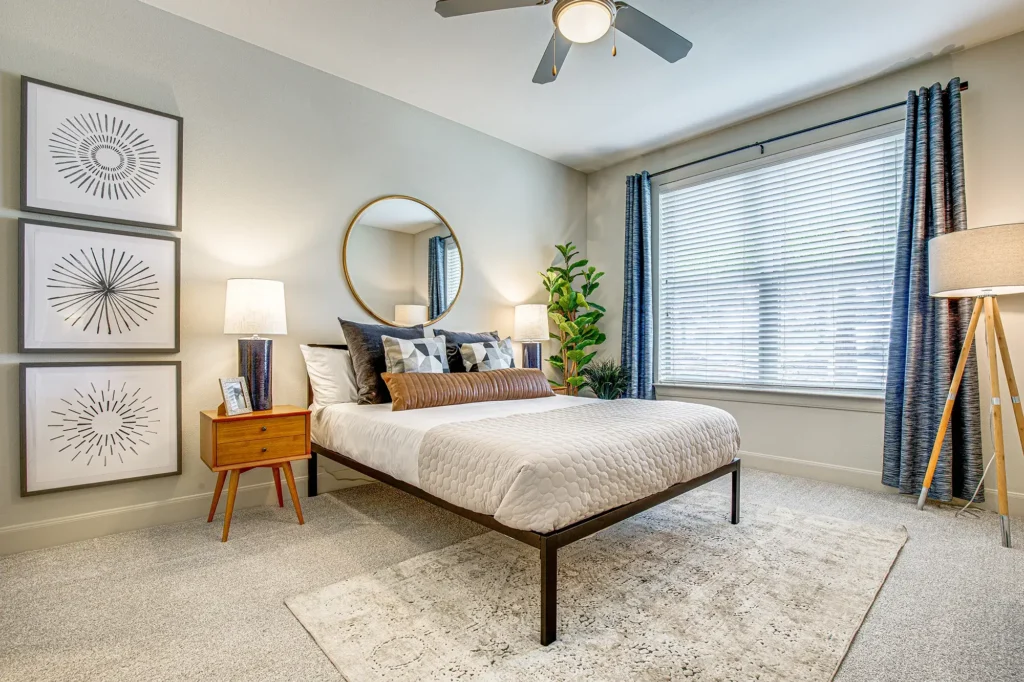 Carpeted bedroom with large window and ceiling fan