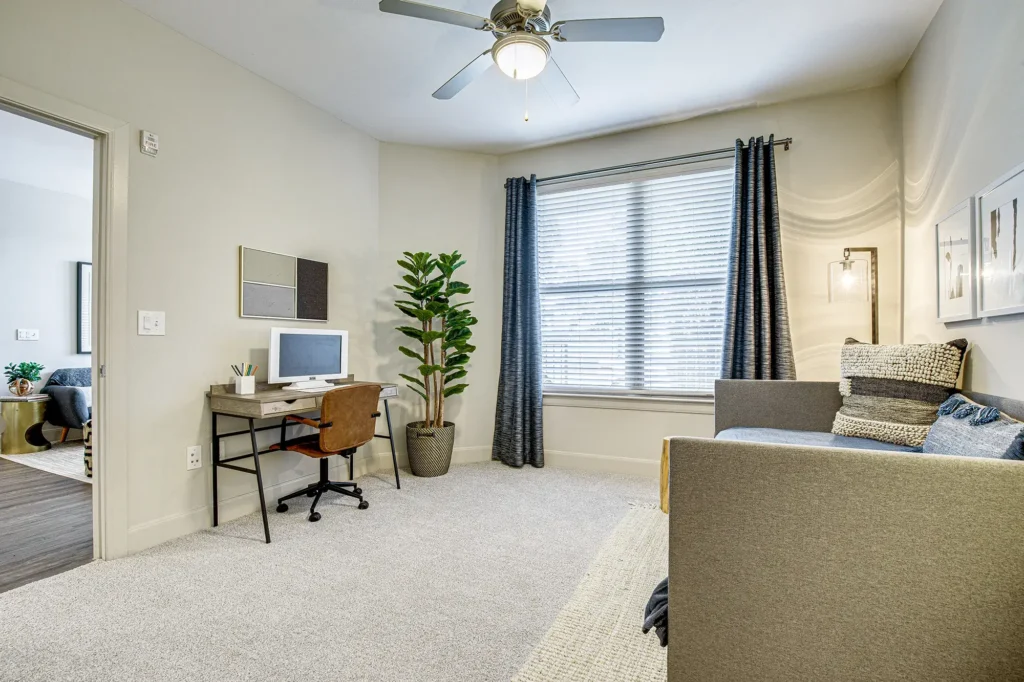 Carpeted bedroom with large window and ceiling fan