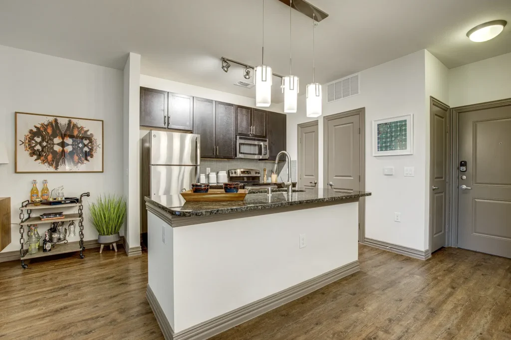 Kitchen with granite counters, stainless steel appliances, and tile backsplash