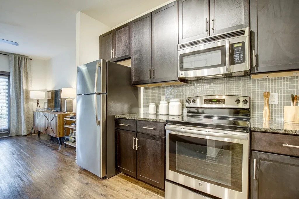 Kitchen with granite counters, stainless steel appliances, and tile backsplash