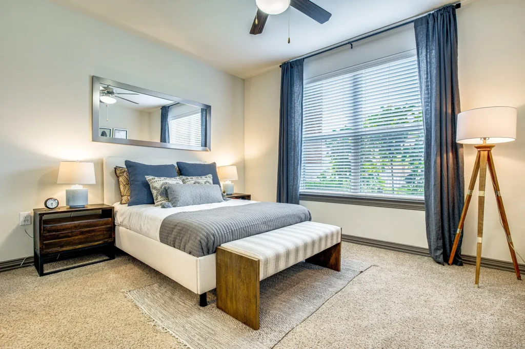Carpeted Bedroom with large window and ceiling fan