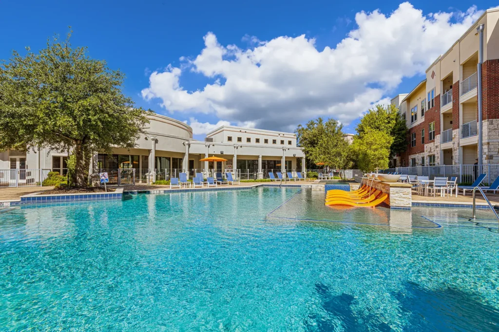 Outdoor pool with deck seating and umbrellas