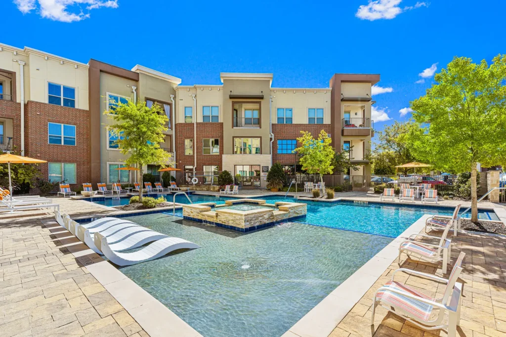 Outdoor pool and hot tub with deck seating and umbrellas