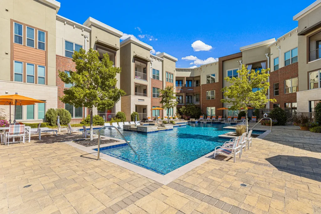Pool courtyard with deck seating and umbrellas